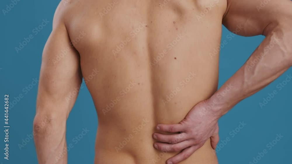 Close up shot of of unrecognizable muscular guy touching his painful right lower, suffering from kidney or loin pain Close up shot of of unrecognizable muscular guy touching his painful right lower, suffering from kidney or loin pain