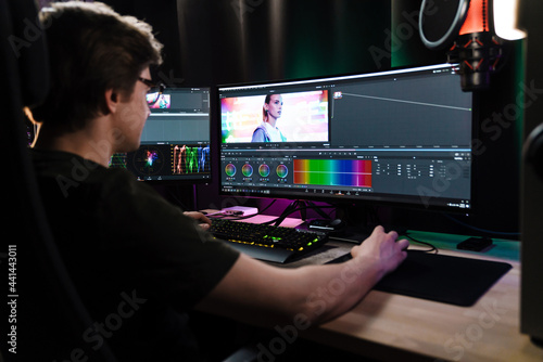 Back view of a young white man videographer working