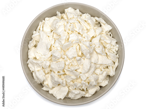 Cottage cheese in a plate. Fresh cottage cheese on a white background. Homemade curd in minimalism style. Top view.