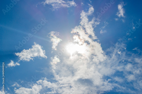 Beautiful blue sky with sun among white clouds