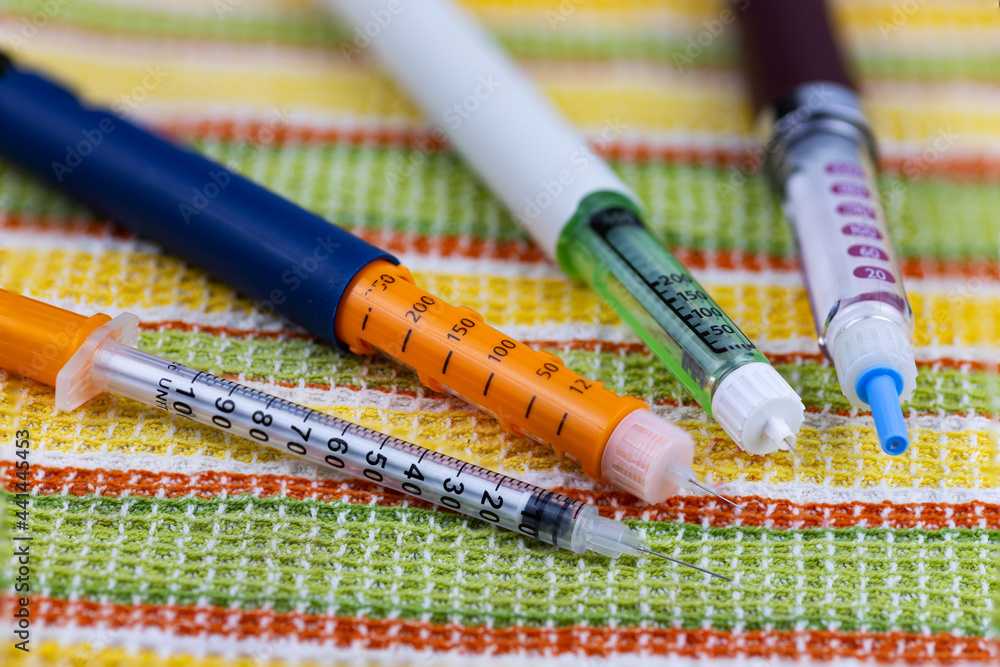 Insulin syringe pens for hormone therapy of diabetic patients on a colored background. Close-up, selective focus.