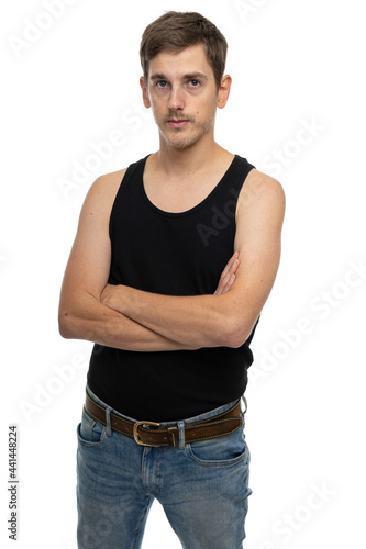 Young handsome tall slim white man with brown hair with crossed hands in black undershirt isolated on white background