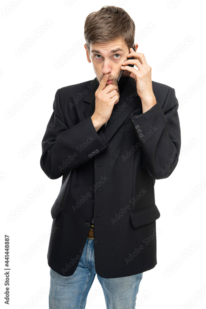 Young handsome tall slim white man with brown hair is on the mobile phone looks confused in black blazer isolated on white background Young handsome tall slim white man with brown hair is on the mobile phone looks confused in black blazer isolated on white background