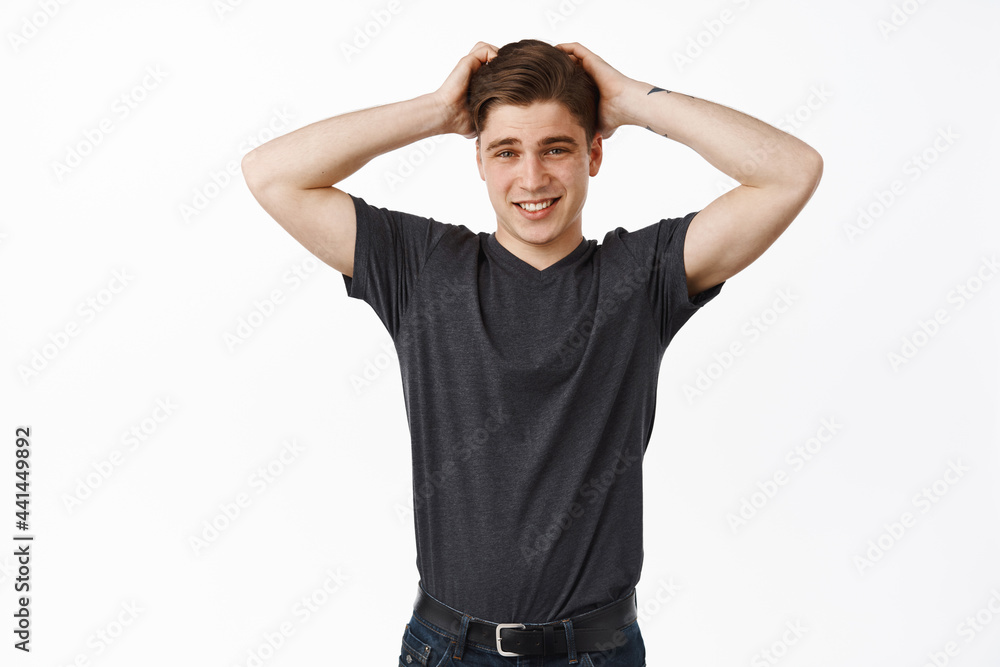 Image of awkward teenage boy, guy scratch head and smiling, blushing and looking embarrassed, dont know what to say, has problem, standing against white background Image of awkward teenage boy, guy scratch head and smiling, blushing and looking embarrassed, dont know what to say, has problem, standing against white background