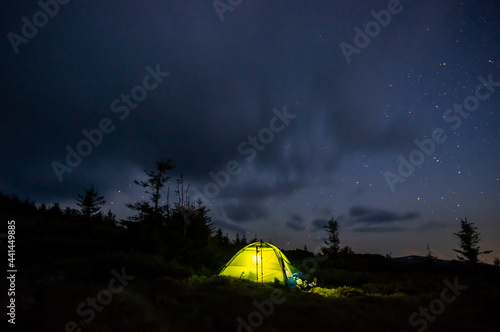 Tent in the mountains against the background of the starry sky