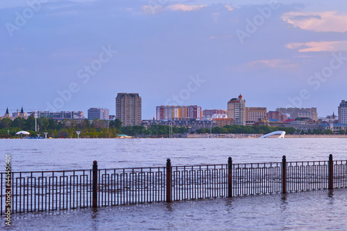 View of the Chinese coast from the flooded embankment of the city of Blagoveshchensk, Russia. Flood of the Amur River. Selective focus, waterfront railing in blur. © Алексей Игнатов