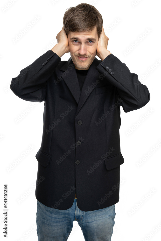Young handsome tall slim white man with brown hair covers his ears in black blazer in blue jeans isolated on white background Young handsome tall slim white man with brown hair covers his ears in black blazer in blue jeans isolated on white background