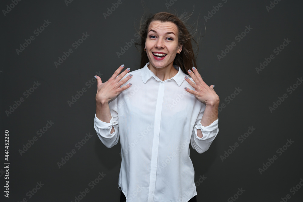 Photo of a young caucasian girl with bright emotions on a gray background with a smile. Photo of a young caucasian girl with bright emotions on a gray background with a smile.