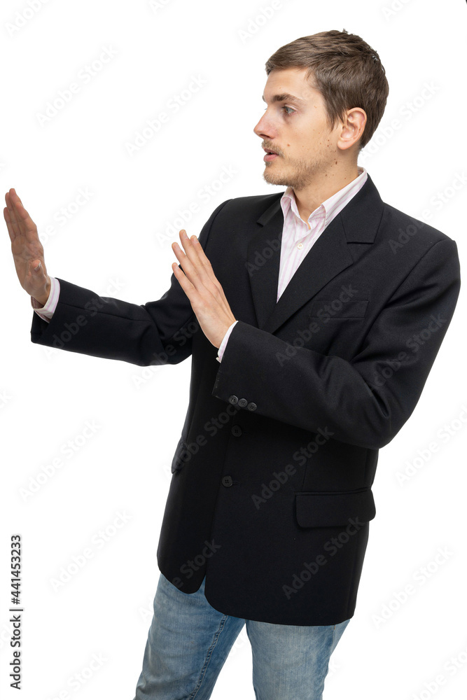 Young handsome tall slim white man with brown hair standing sideways in black blazer in blue jeans isolated on white background Young handsome tall slim white man with brown hair standing sideways in black blazer in blue jeans isolated on white background