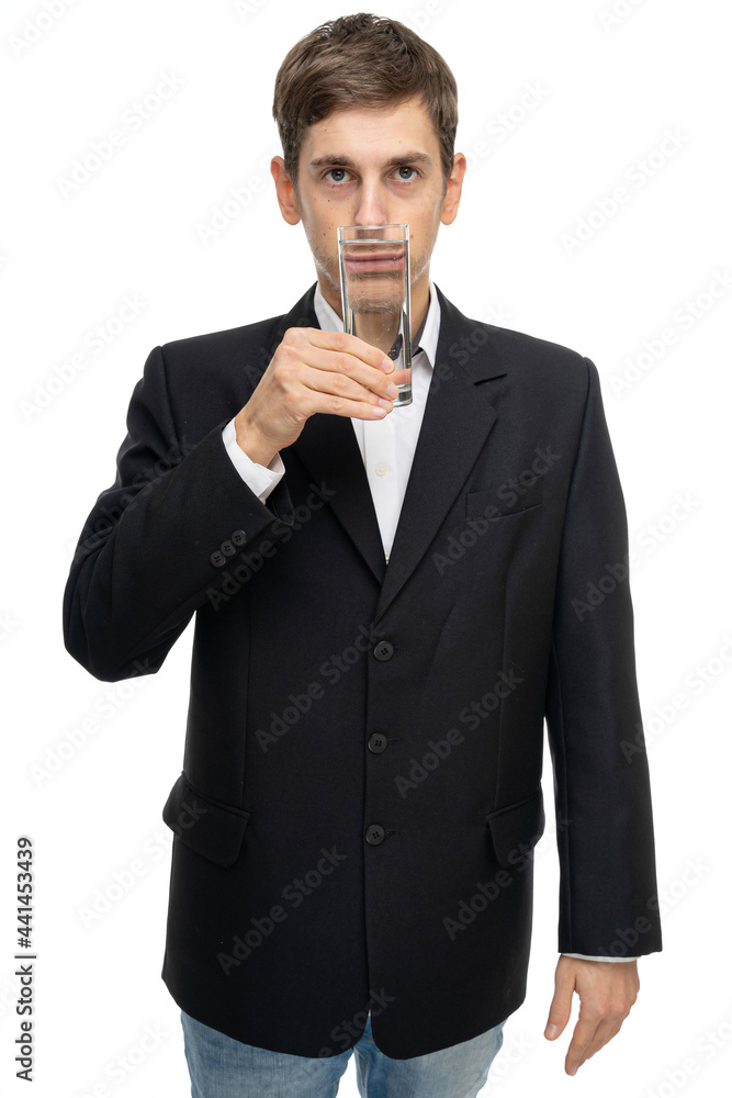 Young handsome tall slim white man with brown hair with glass of water in front of his mouth isolated on white background