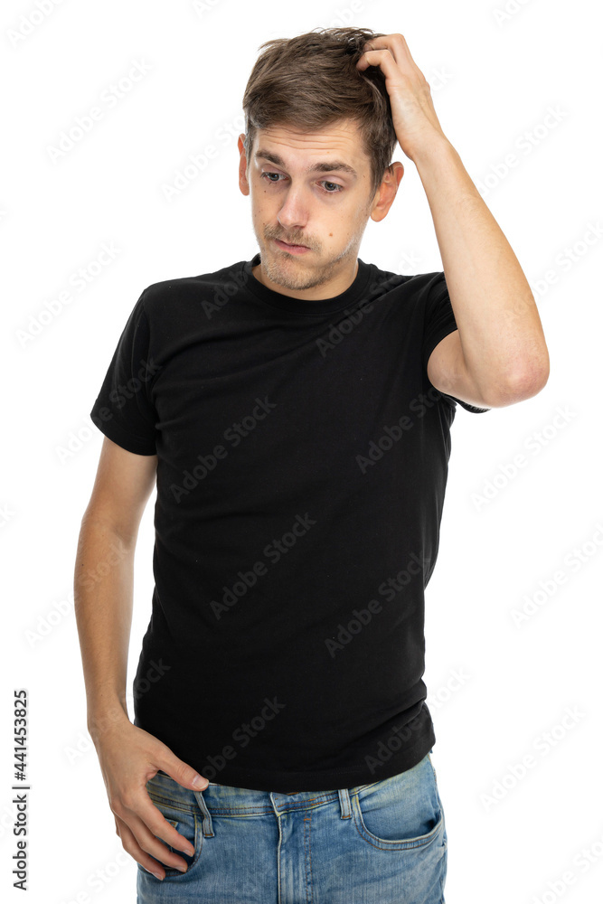 Young handsome tall slim white man with brown hair scratching his head in black shirt in blue jeans isolated on white background Young handsome tall slim white man with brown hair scratching his head in black shirt in blue jeans isolated on white background