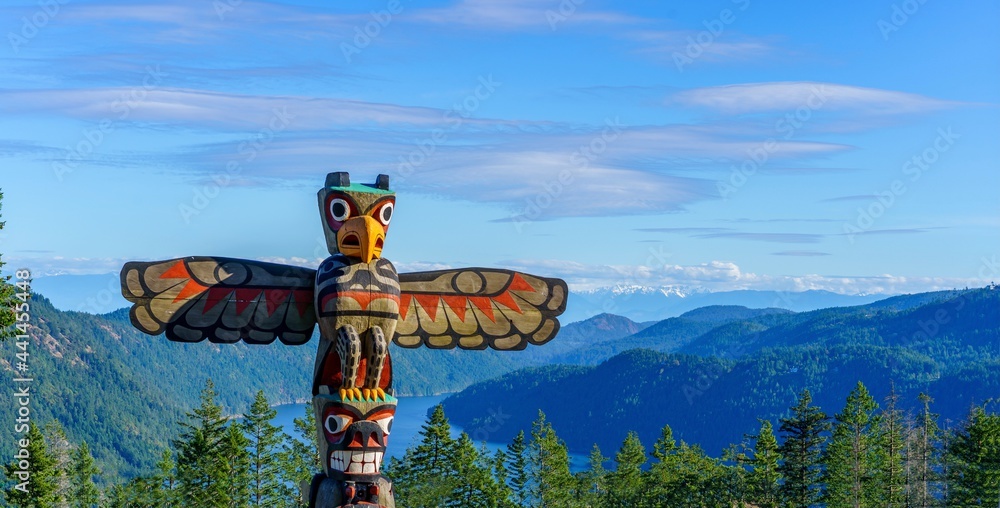 Totem pole towers over scenic wilderness and ocean - obrazy, fototapety, plakaty 