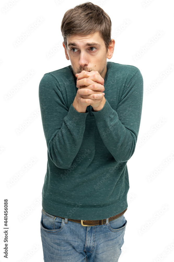 Young handsome tall slim white man with brown hair with clasped hands in dark green sweater in blue jeans isolated on white background Young handsome tall slim white man with brown hair with clasped hands in dark green sweater in blue jeans isolated on white background