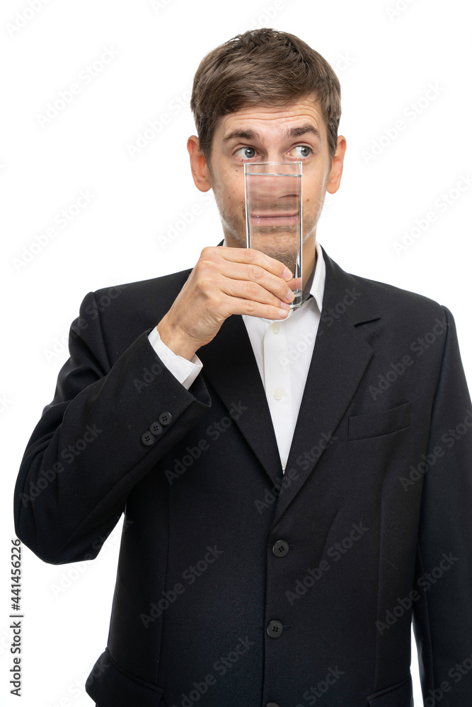 Young handsome tall slim white man with brown hair with glass of water in front of his mouth isolated on white background Young handsome tall slim white man with brown hair with glass of water in front of his mouth isolated on white background