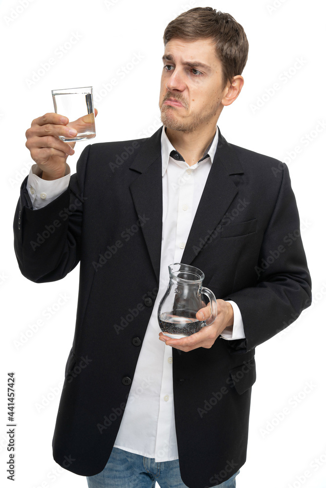 Young handsome tall slim white man with brown hair is disappointed about glass of water in black blazer isolated on white background Young handsome tall slim white man with brown hair is disappointed about glass of water in black blazer isolated on white background