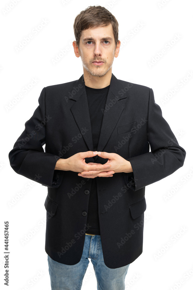 Young handsome tall slim white man with brown hair looks focused with joined hands in black blazer in blue jeans isolated on white background Young handsome tall slim white man with brown hair looks focused with joined hands in black blazer in blue jeans isolated on white background