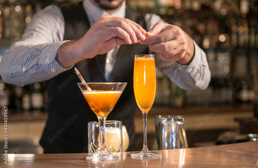 Bartender mixing, squeezing lemon/lime and preparing cocktails and alcoholic beverages in Vancouver cocktail bar and restaurants  