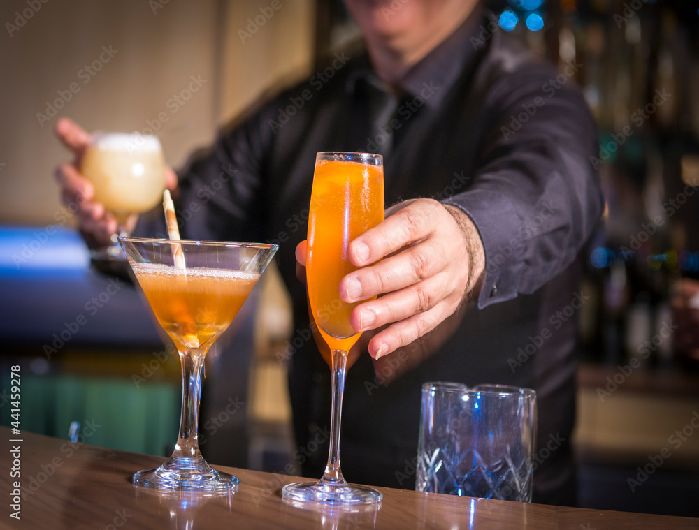 Bartender preparing  and  serving cocktails and alcoholic beverages in Vancouver BC restaurant 