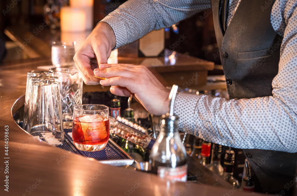 Bartender mixing, squeezing lemon/lime and preparing cocktails and alcoholic beverages in Vancouver cocktail bar and restaurants  