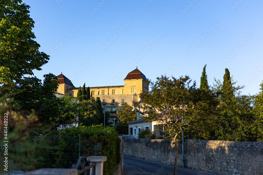 Vue sur le Château de Castries depuis la rue du centre-ville au coucher du soleil (Occitanie, France)