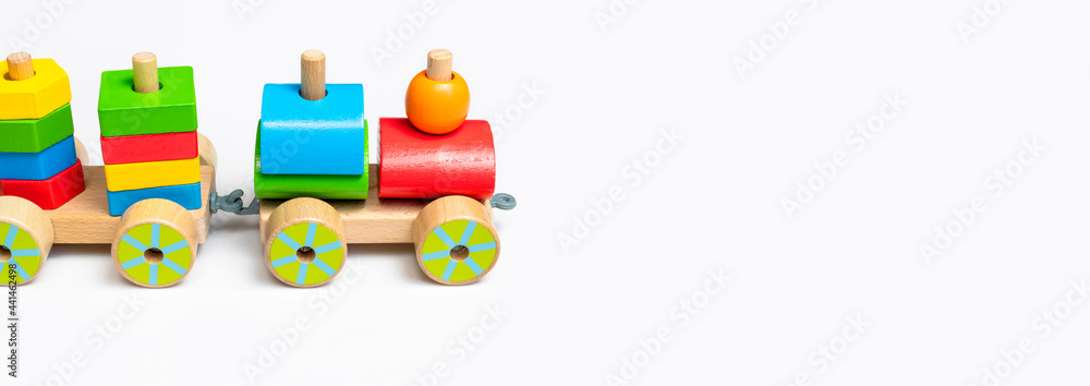 Wooden train with colored blocks on white background. Kids toys made of natural wood in rainbow colors. Eco friendly toy, game, plastic free. Toy for babies and toddlers. Flat lay side view Wooden train with colored blocks on white background. Kids toys made of natural wood in rainbow colors. Eco friendly toy, game, plastic free. Toy for babies and toddlers. Flat lay side view