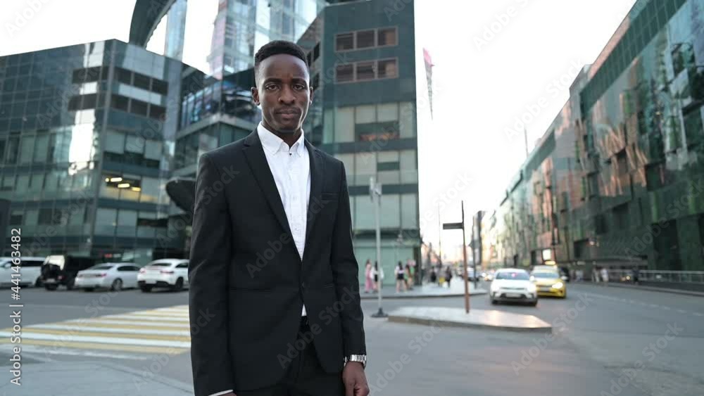 Portrait of a serious strict young black guy on the background of a business center, slow motion Portrait of a serious strict young black guy on the background of a business center, slow motion