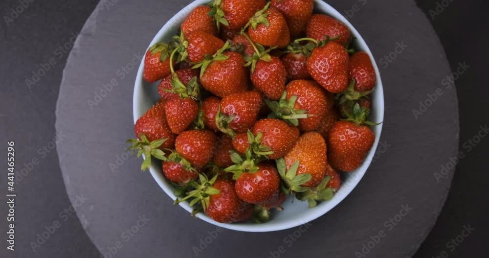 Top-down view of plate with fresh strawberries on grey background. Rotating video. Loop motion. Top-down view of plate with fresh strawberries on grey background. Rotating video. Loop motion.