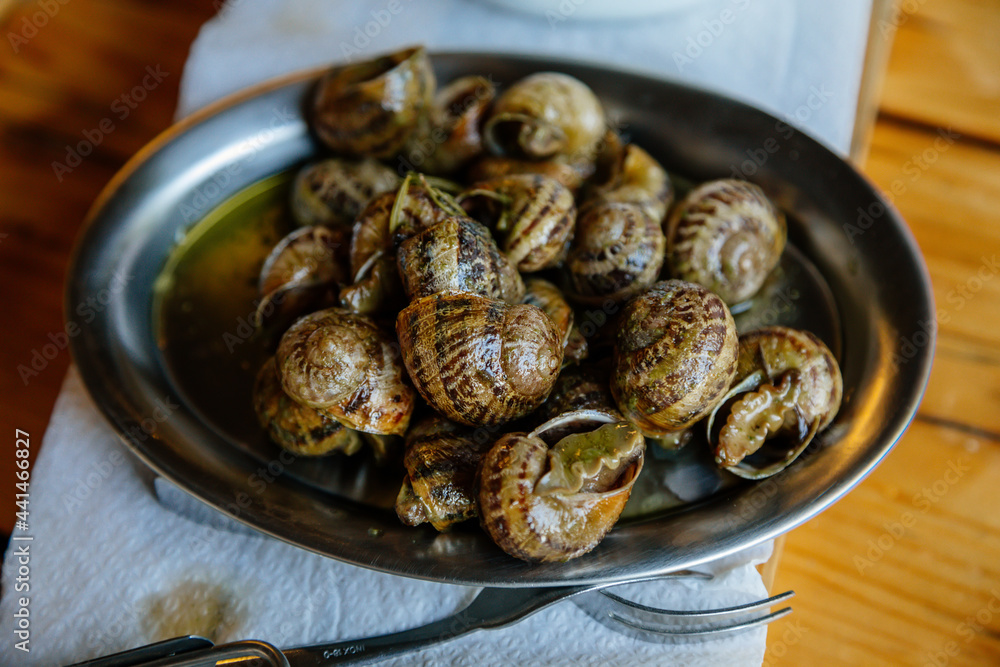 Escargots de Bourgogne, Snails herbs butter, traditional pan with parsley sauce, wooden table, gray background, selective focus, Private snail farm, Prague, Czech Republic Escargots de Bourgogne, Snails herbs butter, traditional pan with parsley sauce, wooden table, gray background, selective focus, Private snail farm, Prague, Czech Republic