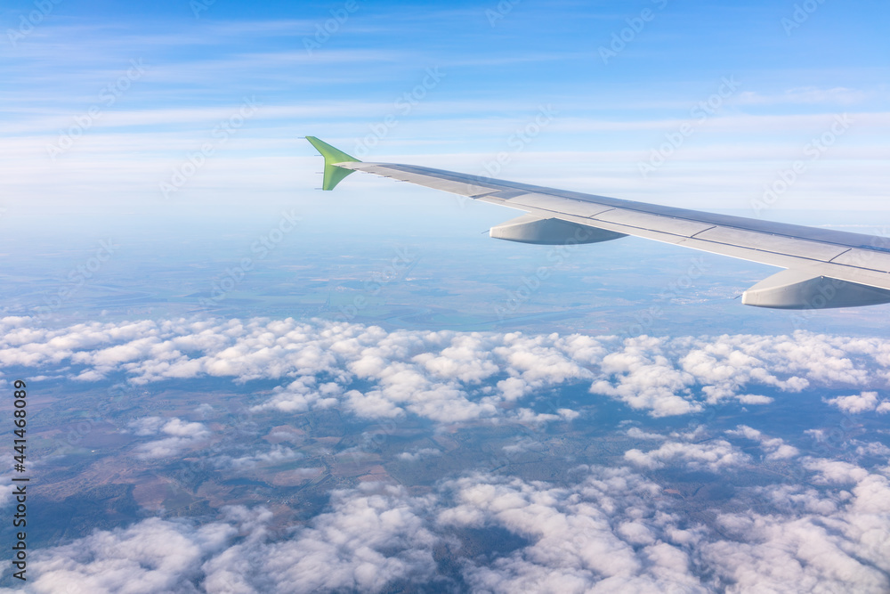 Obraz premium View from the airplane window at a beautiful blue sunrise and the airplane wing above the clouds.