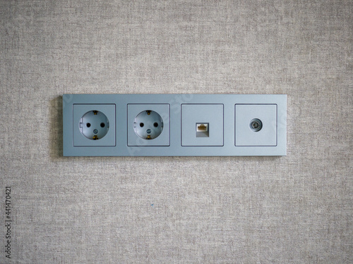 Close-up of a gray four module socket. Double electrical socket, ethernet socket and TV socket.