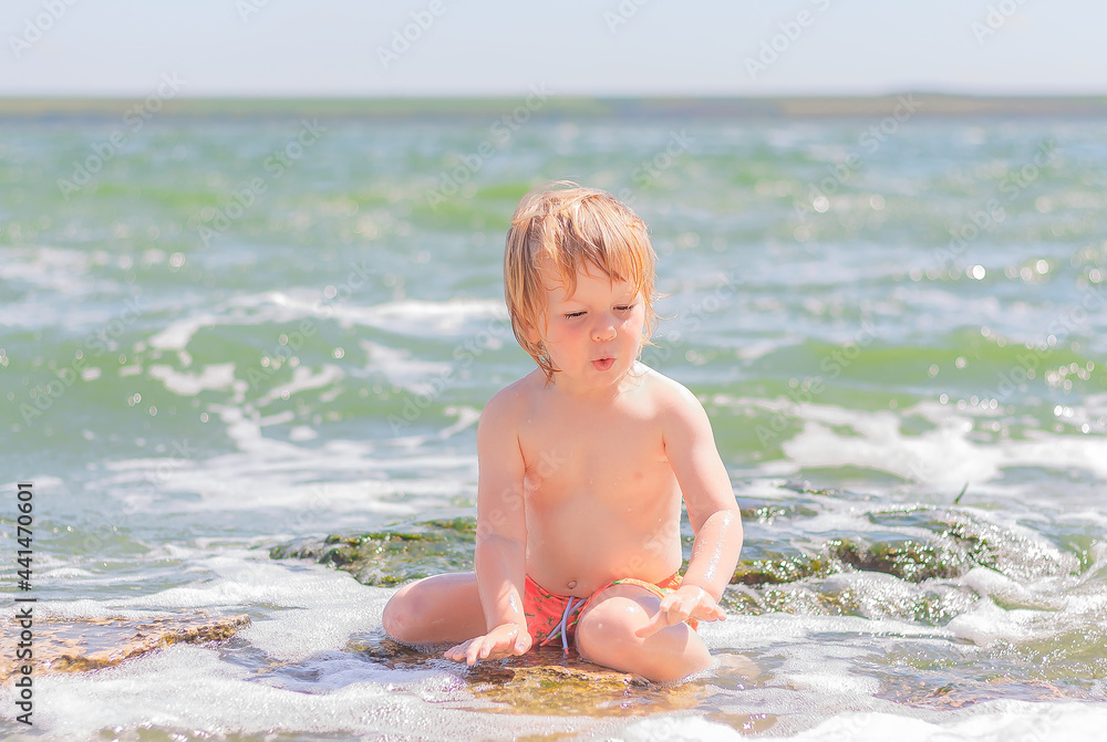 cute child boy sitting in the water on the sea beach. cute child boy sitting in the water on the sea beach.