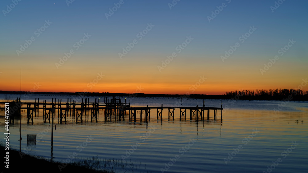 Fishing Pier Sunrise/Sunset Over Still Water mirroring a
Vibrant Colored Sky.
