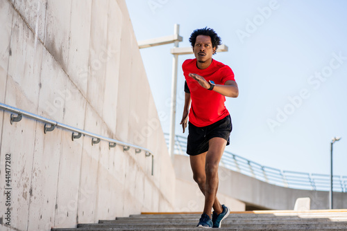 Athletic man running and doing exercise outdoors.