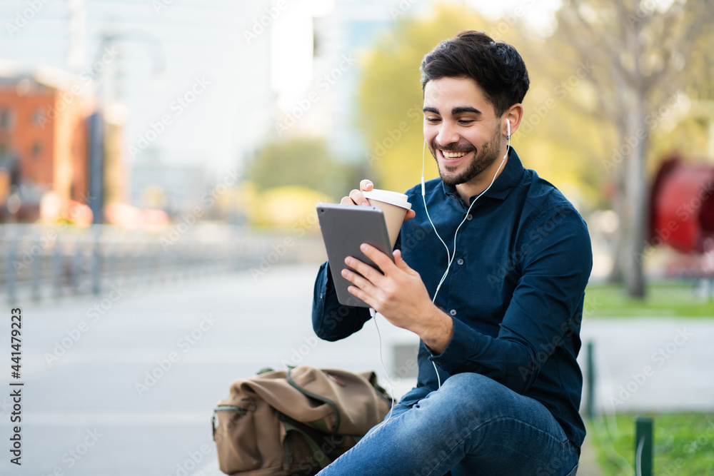 Young man having a video call on digital tablet outdoors. Young man having a video call on digital tablet outdoors.