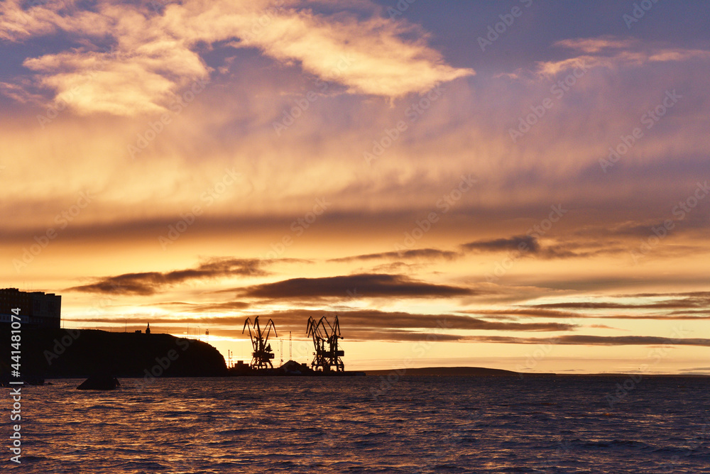 Silhouettes of cranes in the sea port against summer sunset Silhouettes of cranes in the sea port against summer sunset