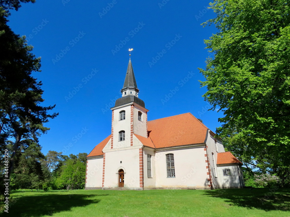Small lutheran church in Liepupe, Latvia, with red roof and white walls. Sunny summer day