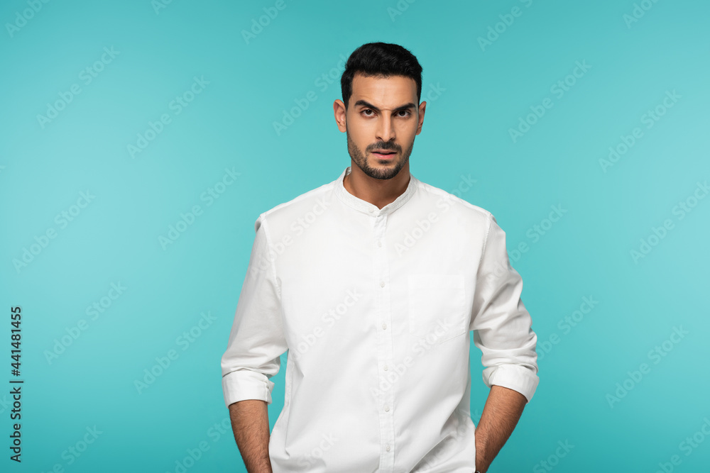 Aggressive arabian man looking at camera isolated on blue Aggressive arabian man looking at camera isolated on blue