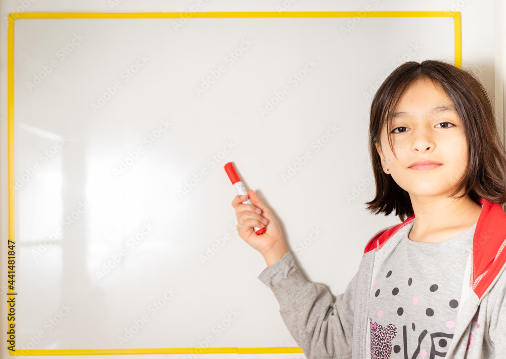 niña escribiendo y pensando en pizarra con fibra en la mano niña escribiendo y pensando en pizarra con fibra en la mano