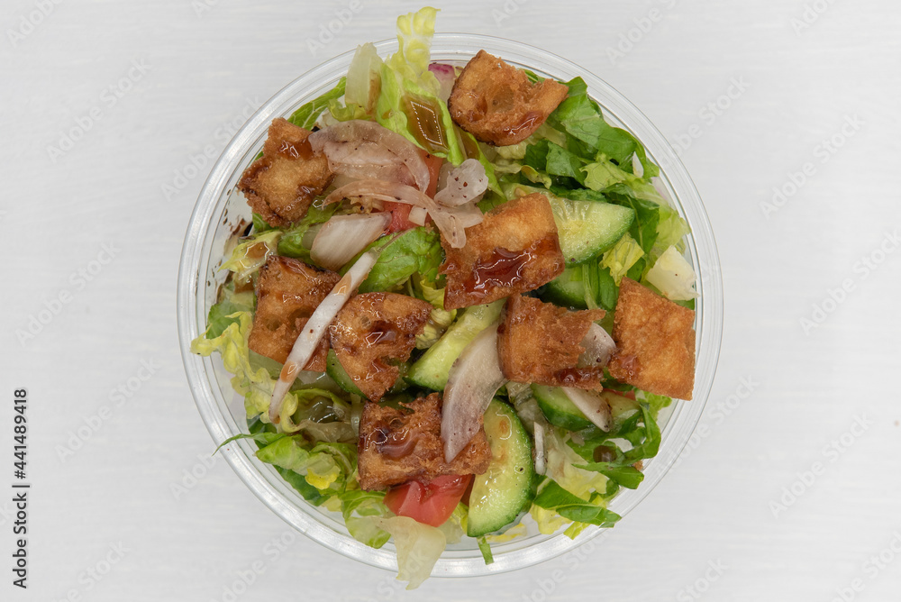 Overhead view of loaded Fatoush salad presented in a clear bowl for a Mediterranean meal on the go Overhead view of loaded Fatoush salad presented in a clear bowl for a Mediterranean meal on the go