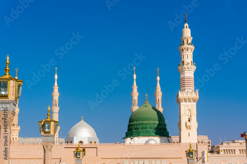Exterior view of minarets and green dome of a mosque taken off the compound.