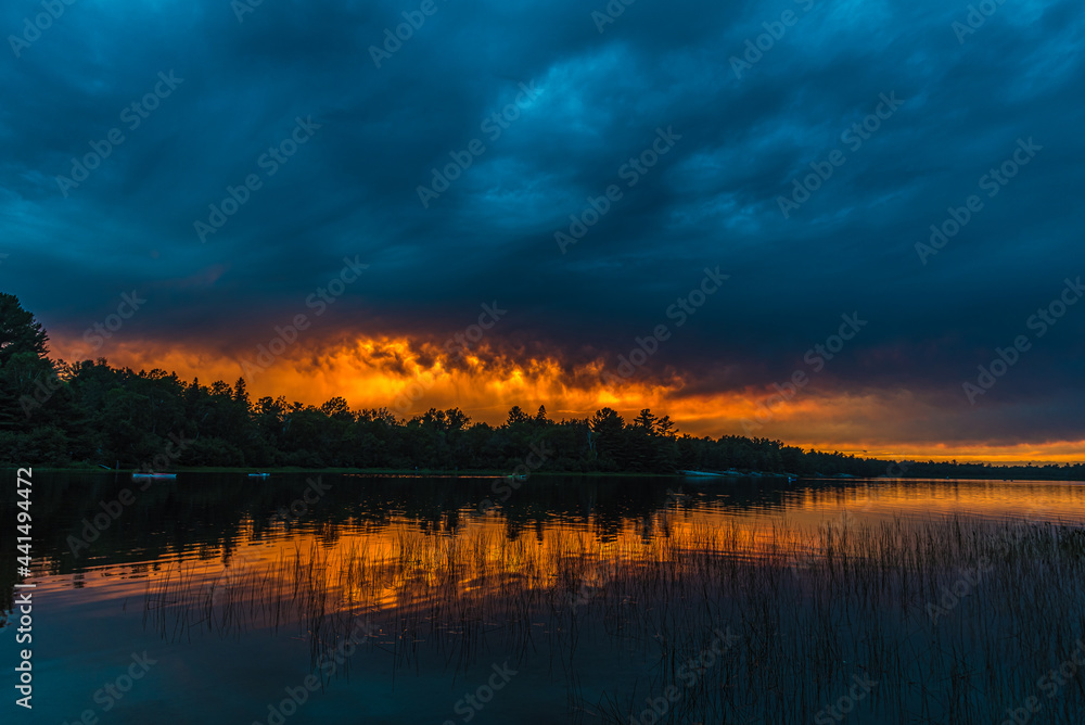 Sunset above forest lake