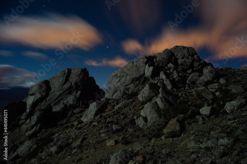Starry night sky at the mountains long exposure moving clouds