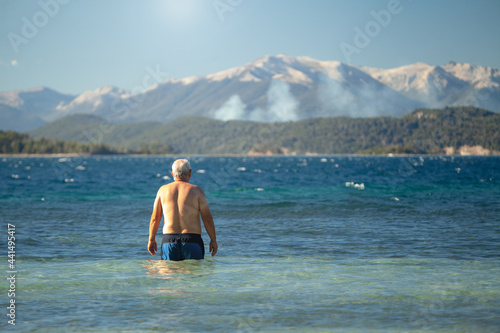 Retired man enjoying the summer at the lake. Freedom concept