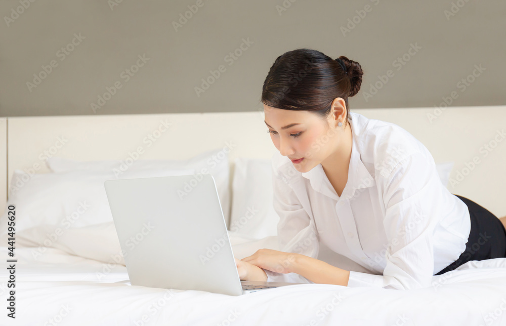 Young woman using laptop computer on bed. Women doing online shopping on the bed. Young woman using laptop computer on bed. Women doing online shopping on the bed.