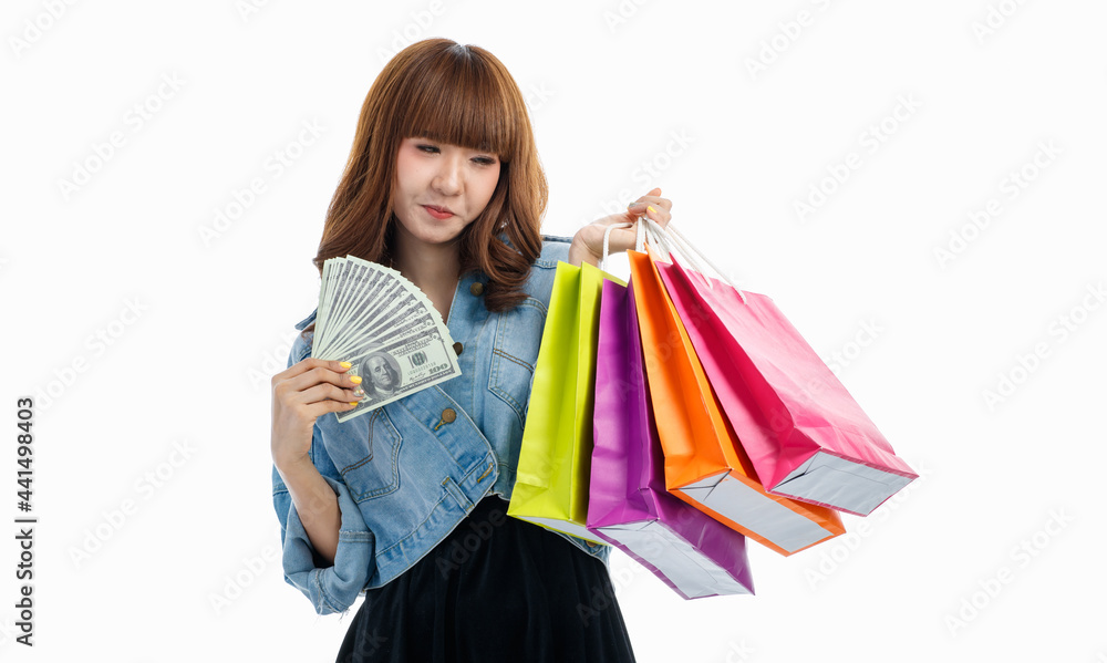Woman holds American banknotes and shopping bags..