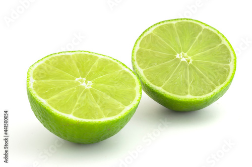 Lime in section isolated on white background. Ripe green citrus for cocktails and alcoholic beverages.