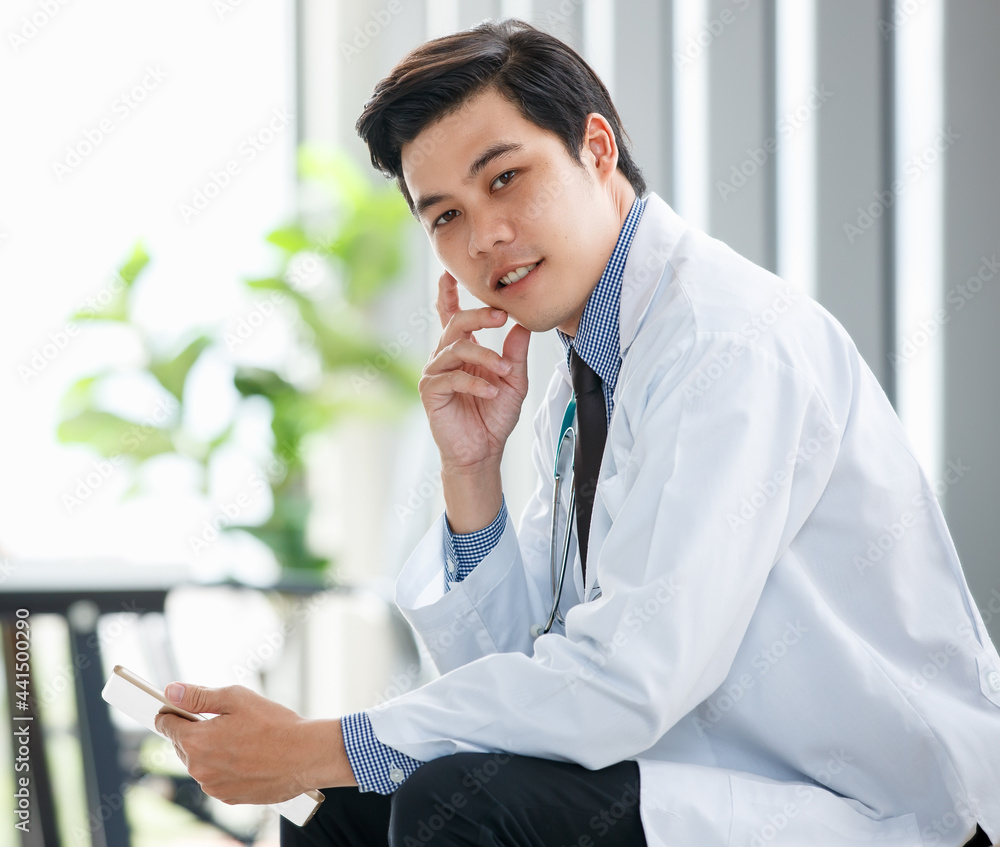 Male doctor using smartphone in medical office Male doctor using smartphone in medical office