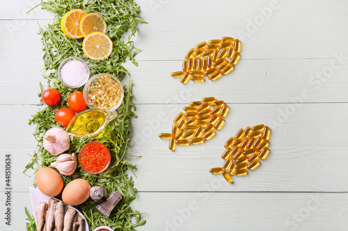 Composition with fish oil pills on light wooden background