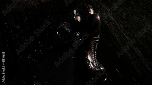 Female latex fetishist dancing in the rain in the dark photo