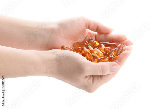 Female hands with fish oil capsules on white background